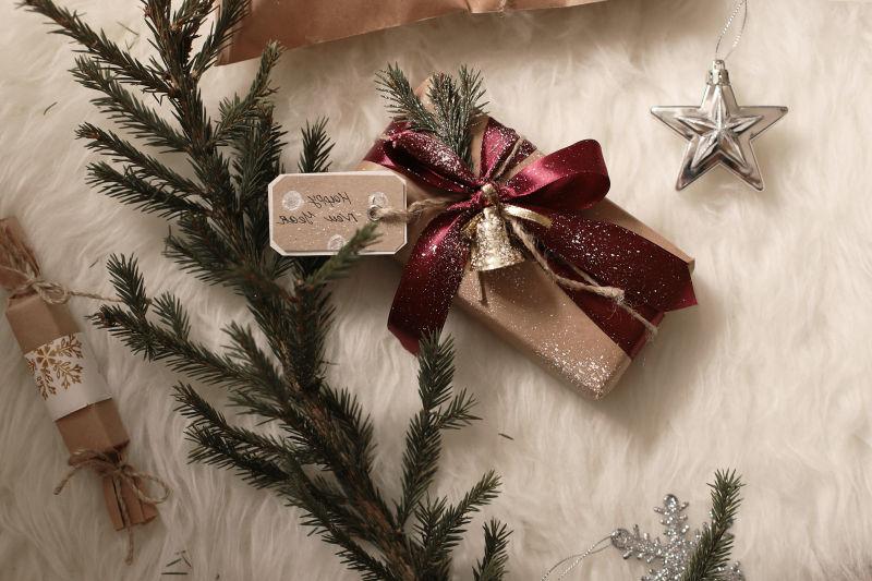 白色毛毯上的松树枝和装饰好的新年礼物