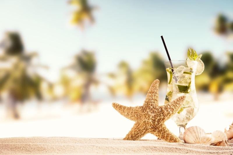 夏日沙滩上的海星和一杯柠檬汁