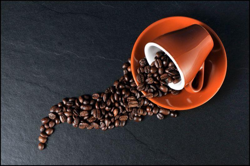 桌子上从咖啡杯里洒落的咖啡豆