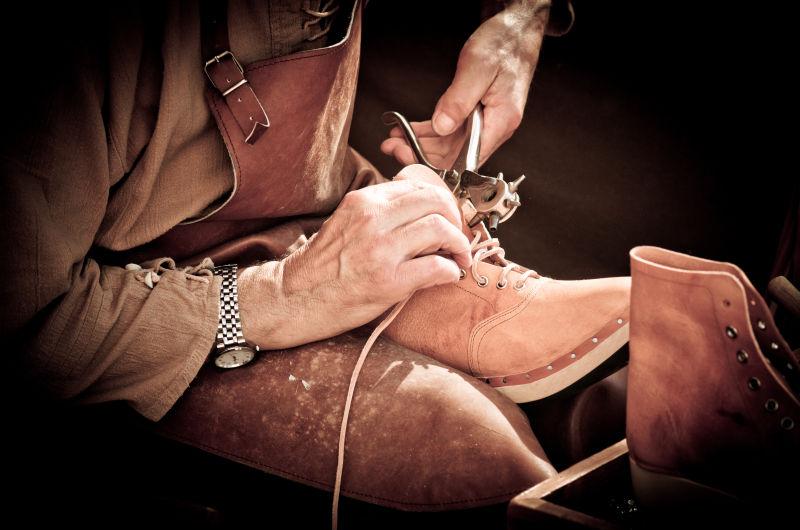 拿着工具修理鞋子的鞋匠
