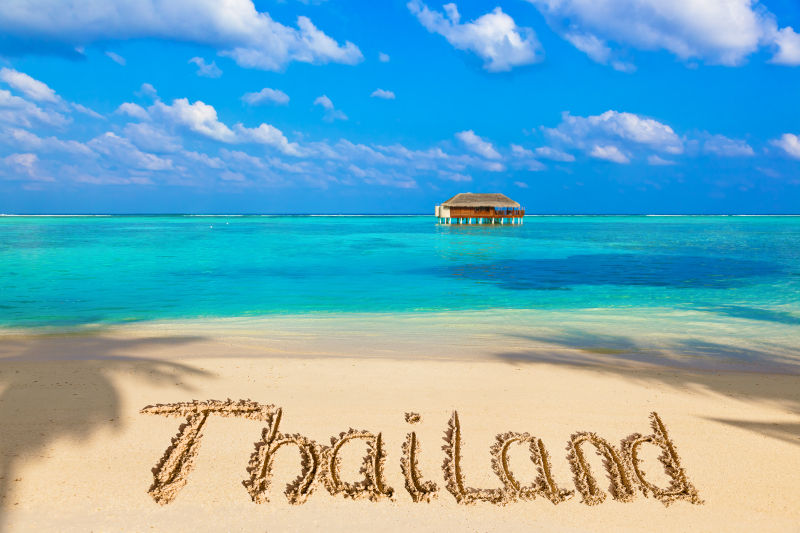 蔚蓝海边的沙滩上刻写这泰国的英文字