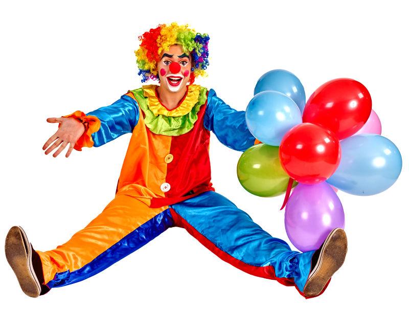 白色背景上的伸直腿坐在地板上手拿一串气球的小丑