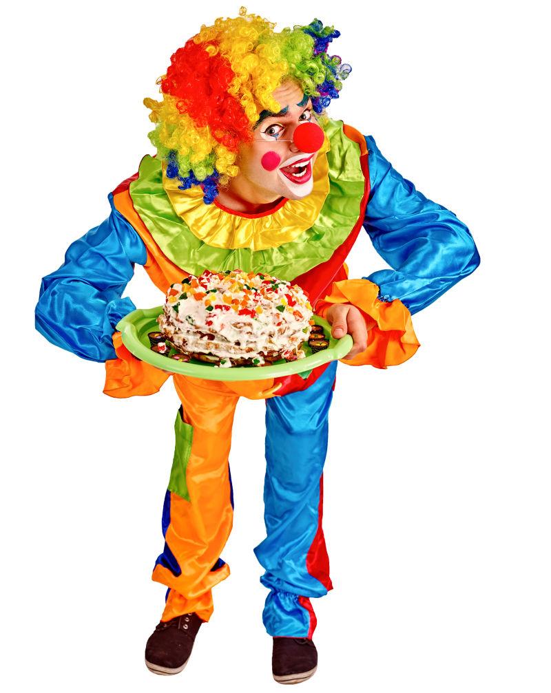 白色背景上的端着生日蛋糕弯着腰的小丑