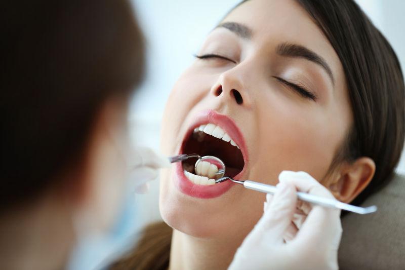 牙医用仪器检查年轻美女牙齿