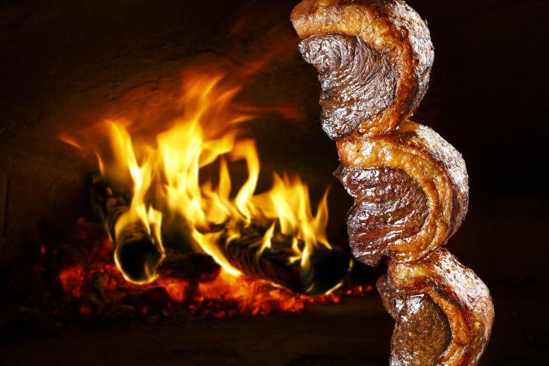 黑色有火焰的背景下的已被烤熟的刚出炉的烤肉串