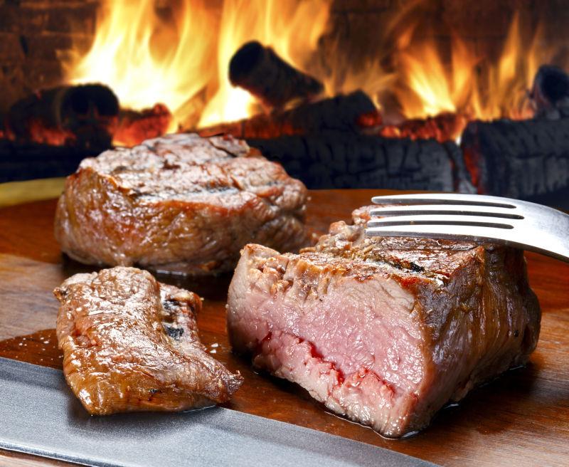 炭火前的桌上被切开的熟烤肉