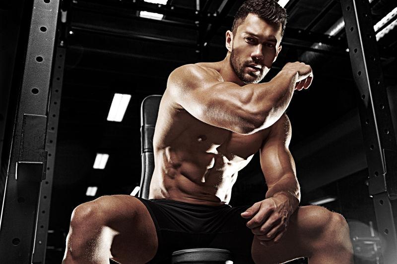 在健身房展示胳膊肌肉的健美肌肉男