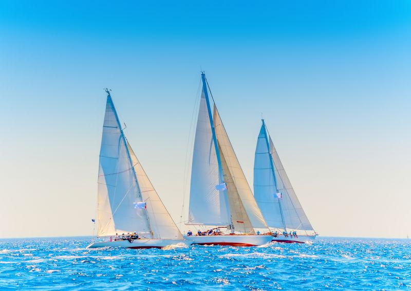 蓝色海面上行驶的三艘帆船