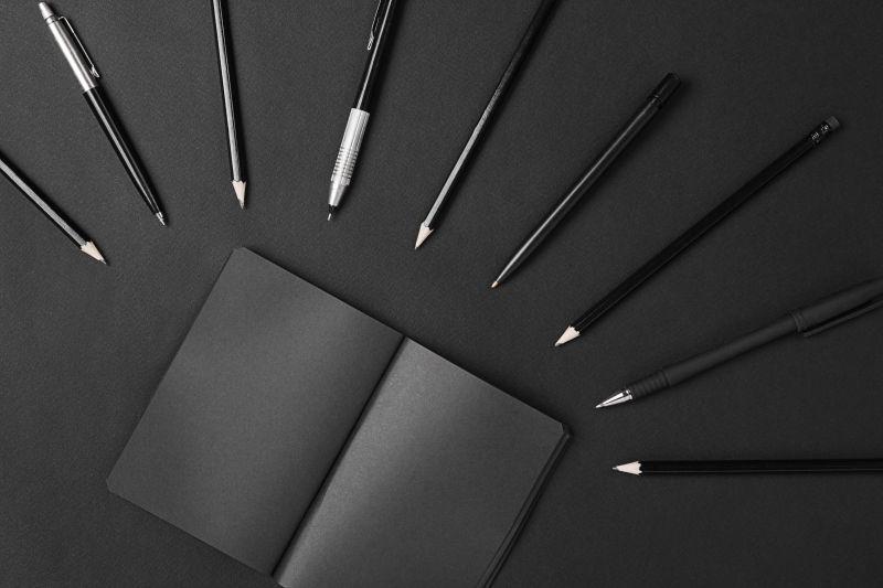 黑色背景中的品牌黑色笔和文件夹