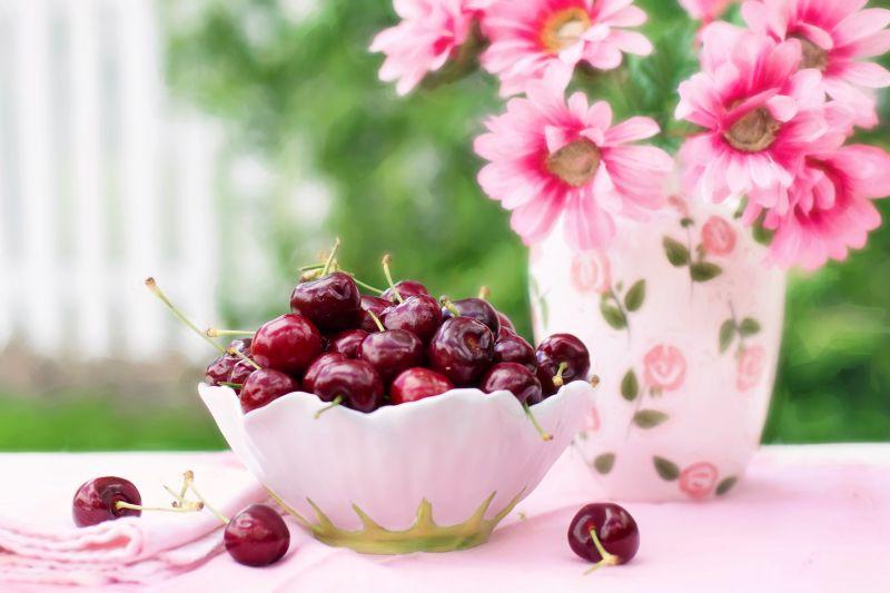 桌子上的一碗樱桃和花朵