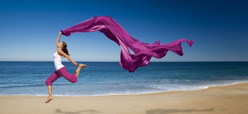 海滩上挥舞这紫色丝带的美女