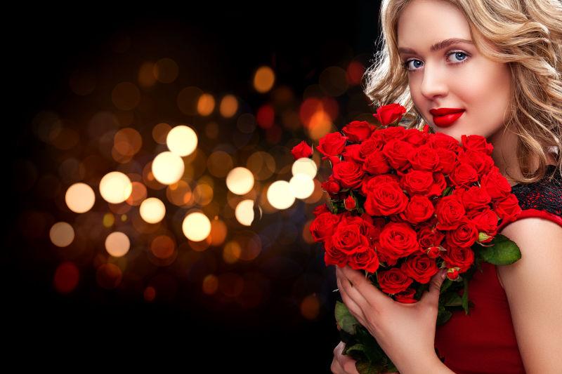 一个年轻漂亮的金发女人与玫瑰花束