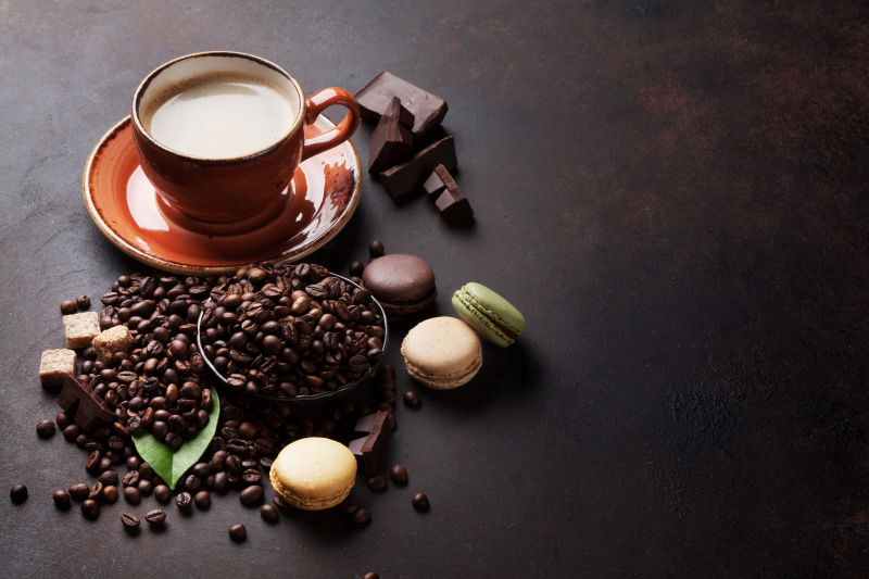 一杯咖啡旁的咖啡豆和马卡龙