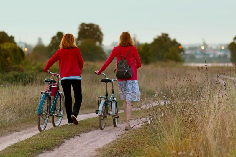 骑自行车的两个穿红色衣服的女性
