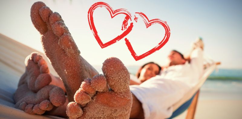 沙滩上的情侣的脚沾满沙子