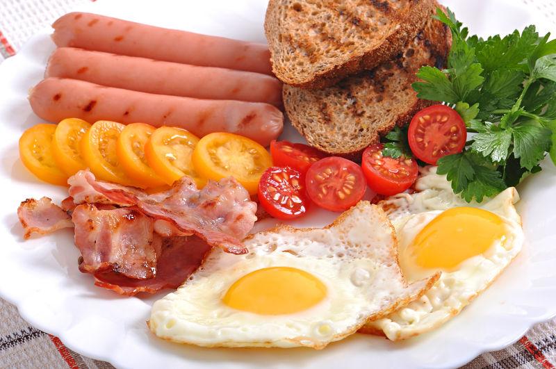 白色餐盘里的火腿番茄和鸡蛋早餐