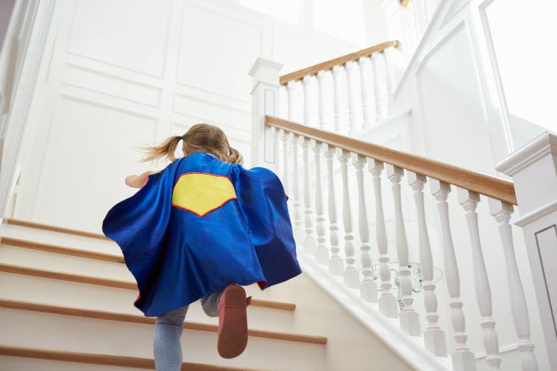 打扮成超级英雄的女孩在楼梯上玩游戏