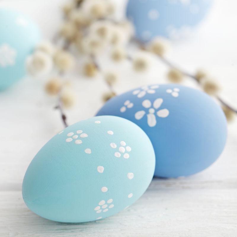 白色桌上的蓝色有小花的复活节彩蛋
