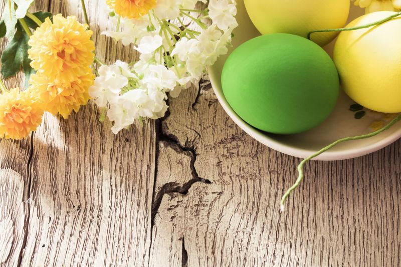 碗里的复活节彩蛋和桌上的花朵