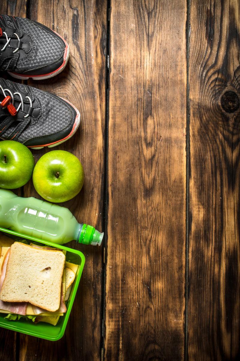 木桌上的健康食物和运动鞋