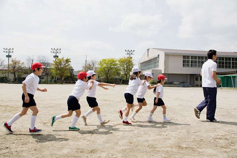 学龄儿童随教师在体育课玩耍