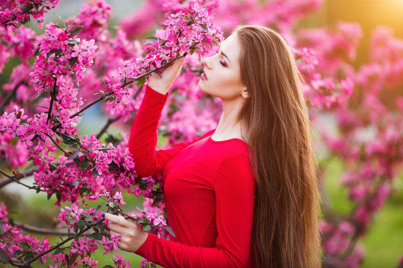 公园中闻鲜花的美女