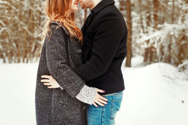 在冬天雪地里亲吻的情侣