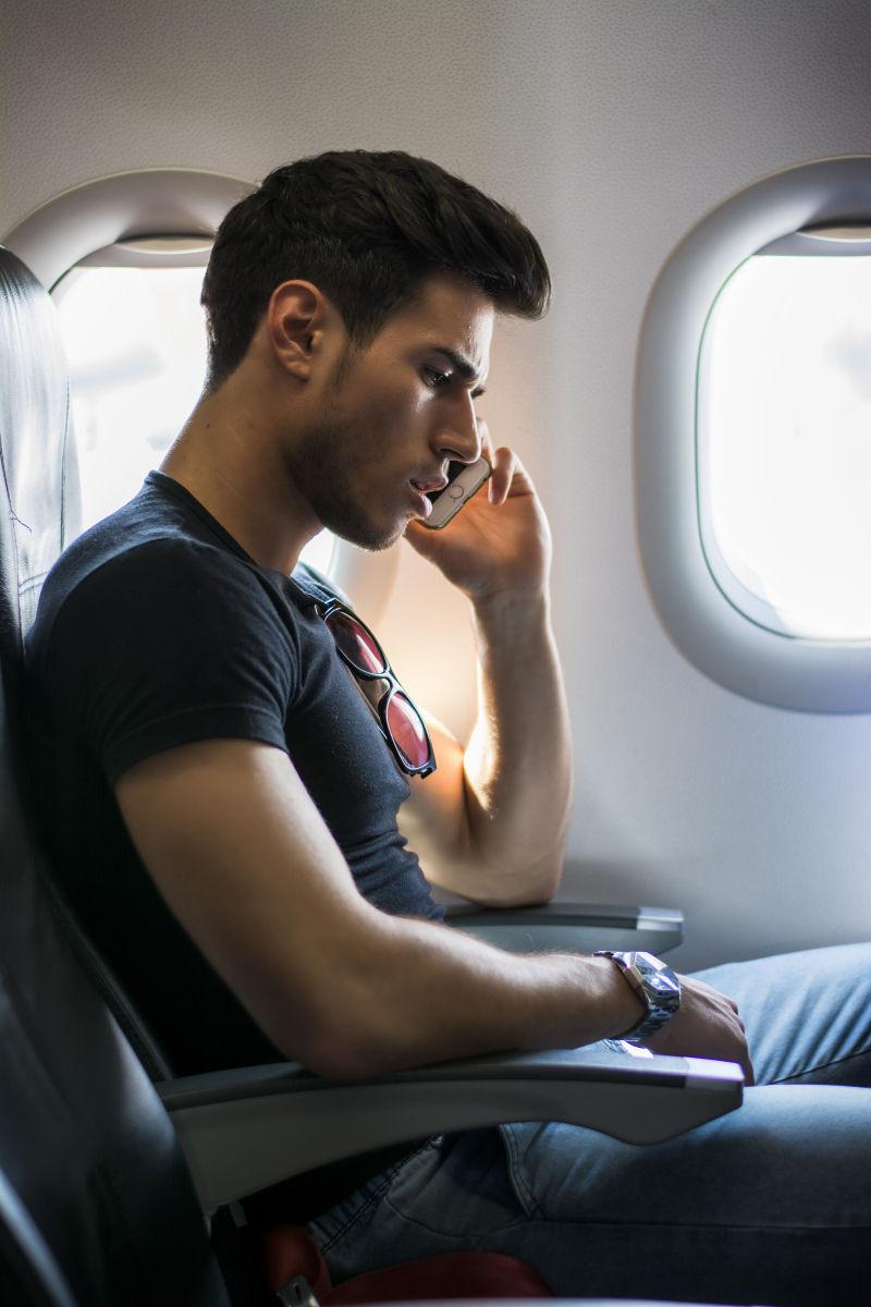 飞机上坐在窗边的时尚帅哥