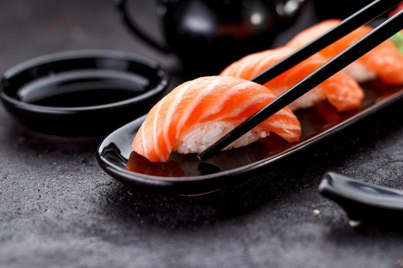 三文鱼的寿司在黑板上用筷子