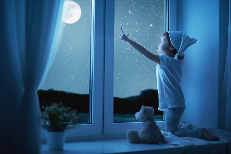 隔着窗户指月亮的小女孩