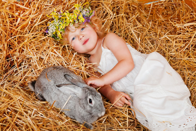美丽的小女孩与小兔子躺在干草上