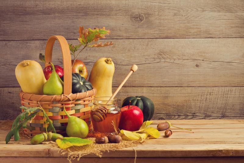 木背景上的篮子里的水果蔬菜和蜂蜜