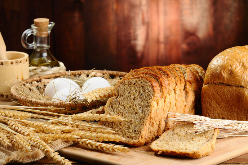 木桌上的全麦面包与小麦