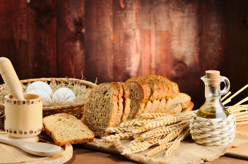木桌上的小麦和切片面包