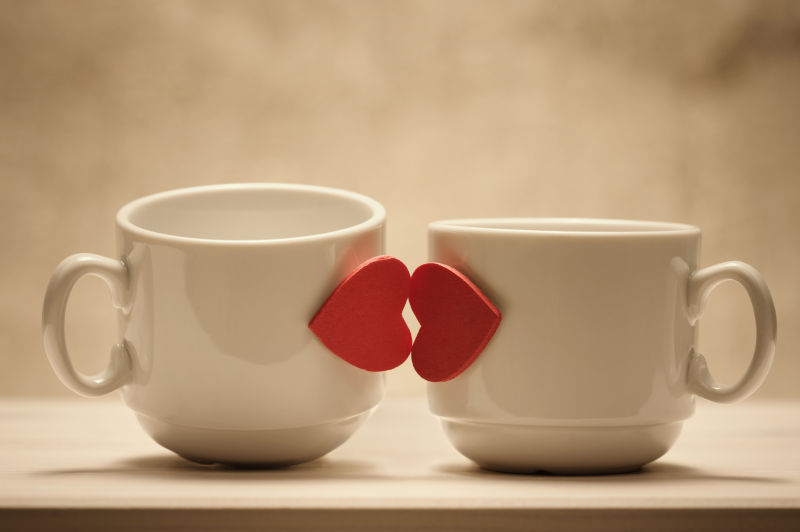 木桌上的两个红心咖啡杯亲吻唇