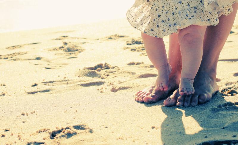 沙滩上妈妈和宝宝的脚