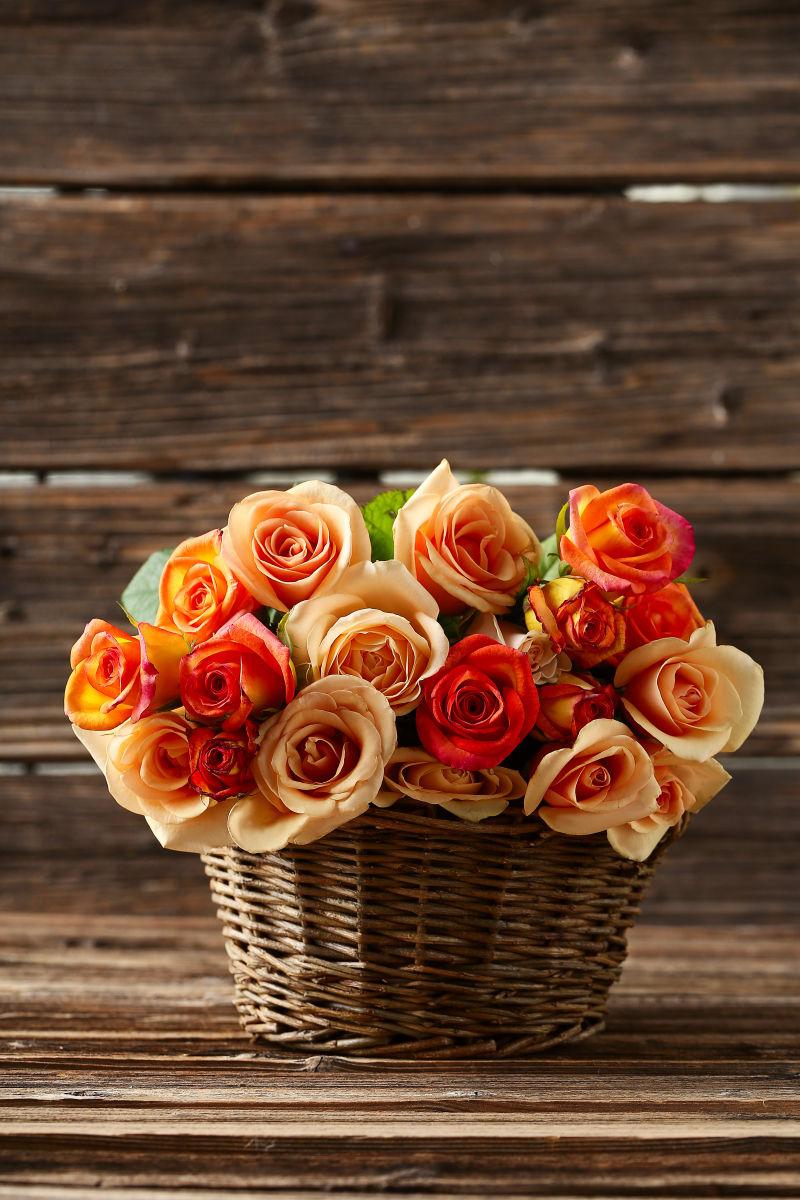 棕色木制篮子中的橙色玫瑰花束