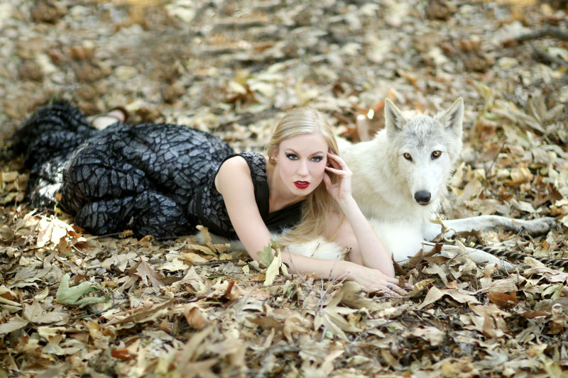 躺在树叶堆的美女与狼狗