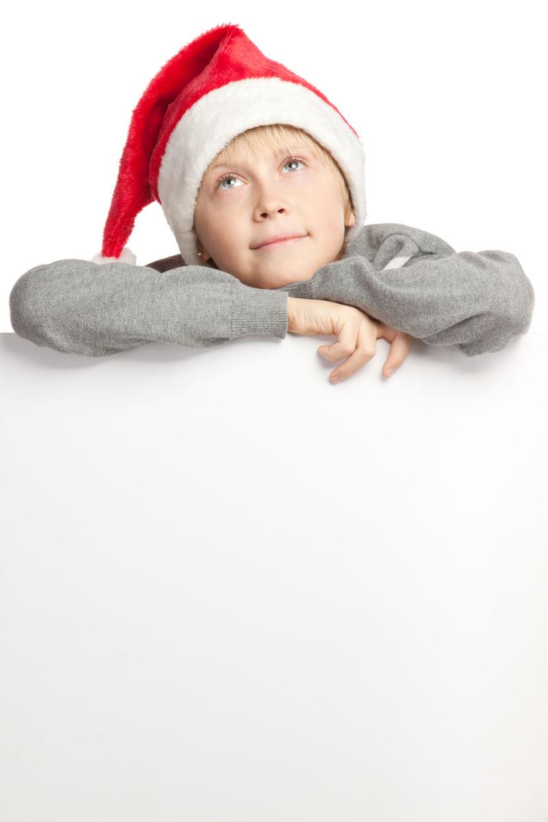 白色背景中带着圣诞帽向上看的小孩