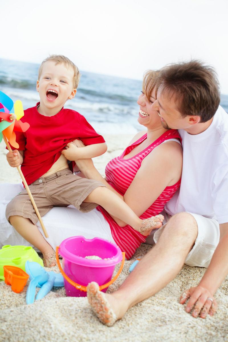 坐在海滩上的快乐幸福的一家人