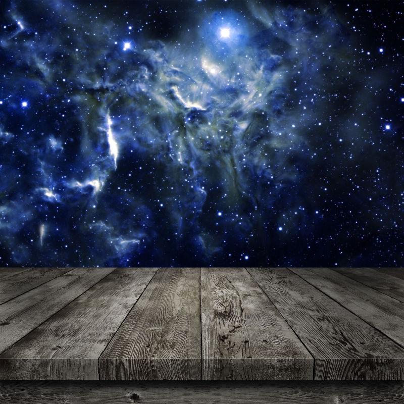 夜间梦幻的星系自然背景前的木桌