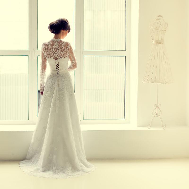 站在白色窗边的新娘