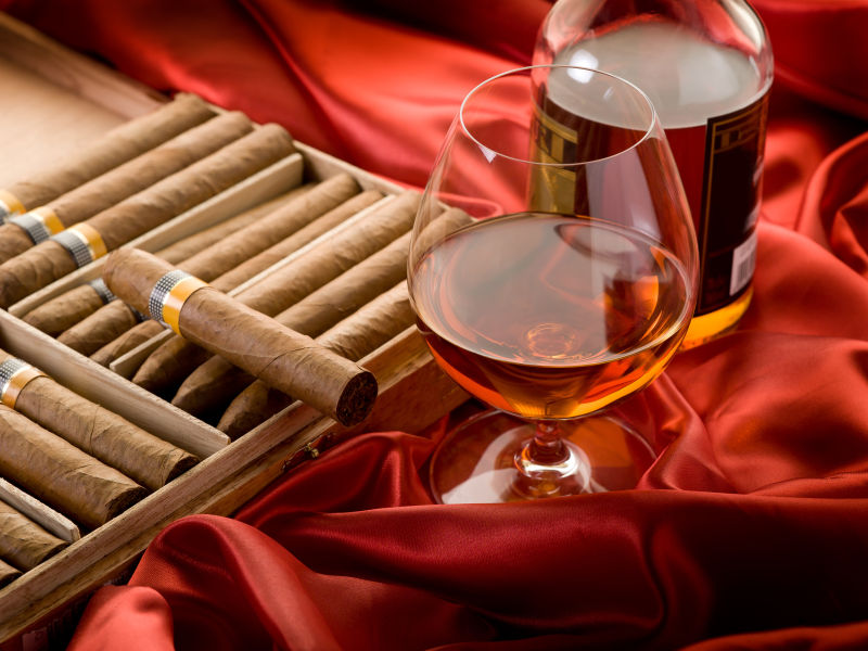 雪茄和洋酒再红色的布上
