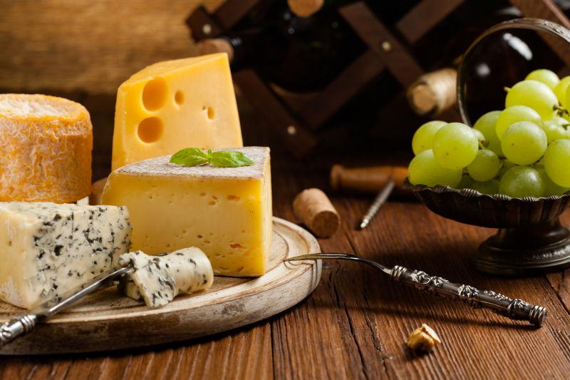 木板上的奶酪和葡萄放在一起