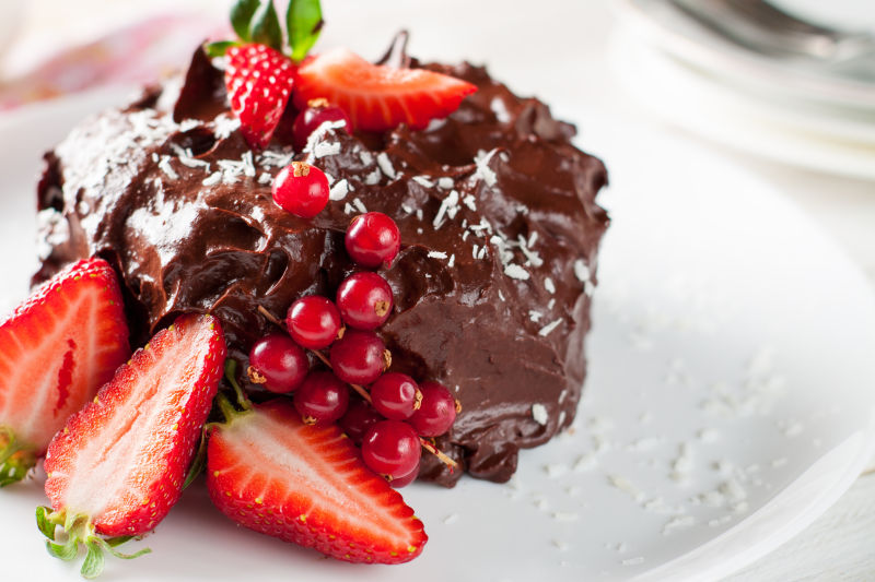 白色盘子里的红色浆果巧克力蛋糕