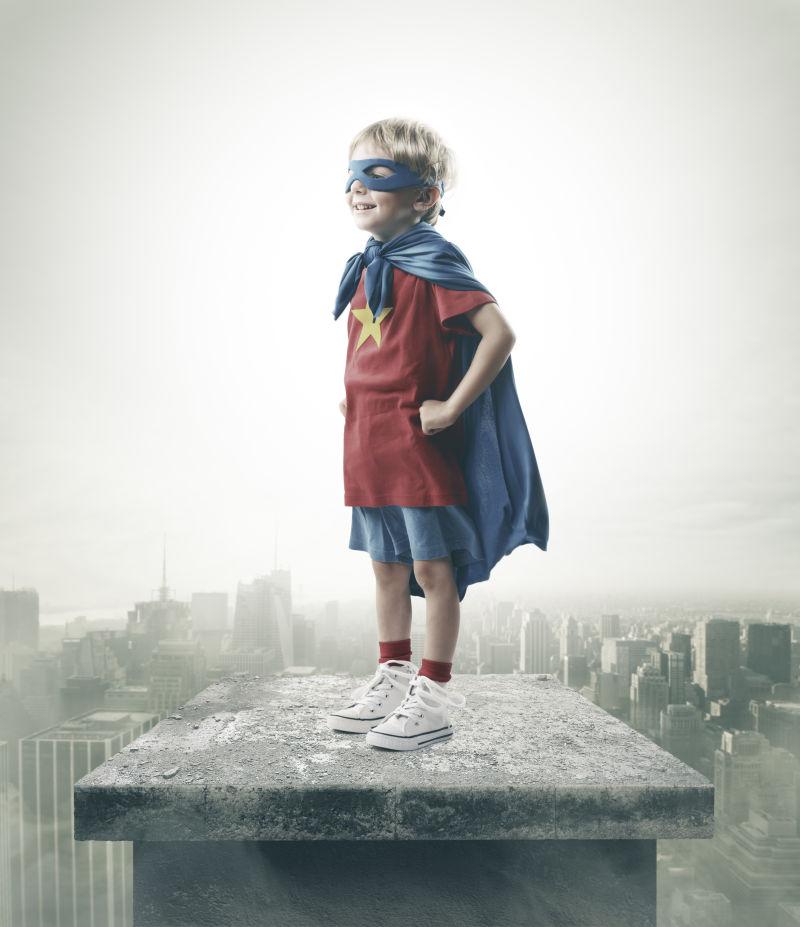 站立在楼顶的做超级英雄梦的小男孩