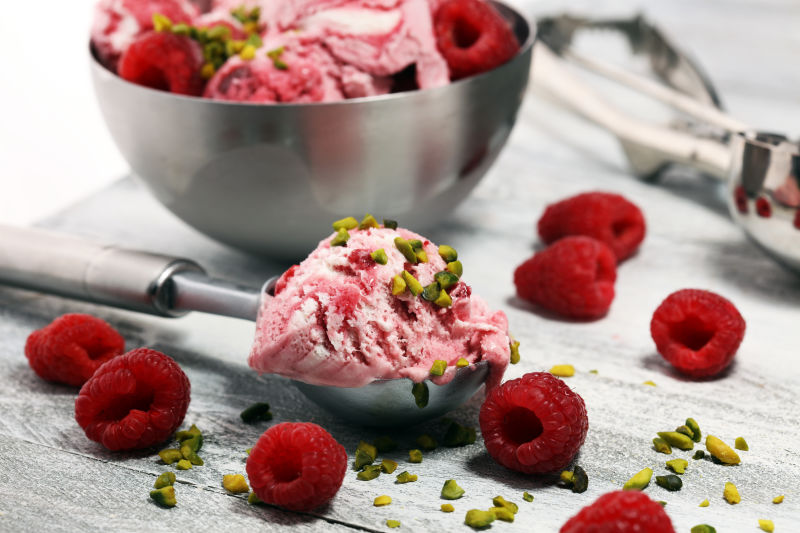 草莓和覆盆子冰淇淋勺-碎坚果和白巧克力-质朴的背景