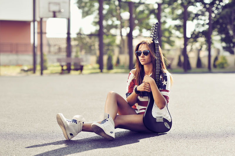 漂亮时尚的年轻女子用吉他摆姿势