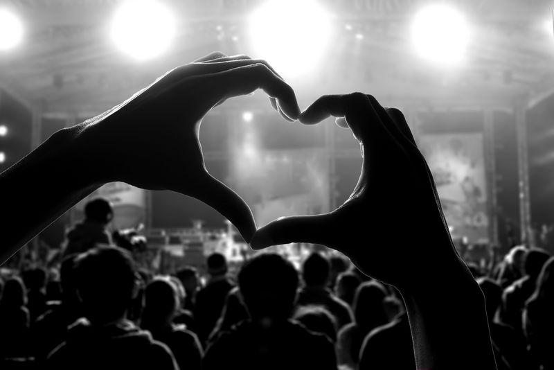 一群人在音乐会上用心形的手影