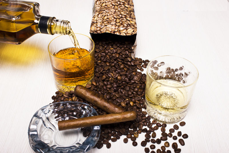 一瓶威士忌和一杯古巴雪茄和咖啡豆